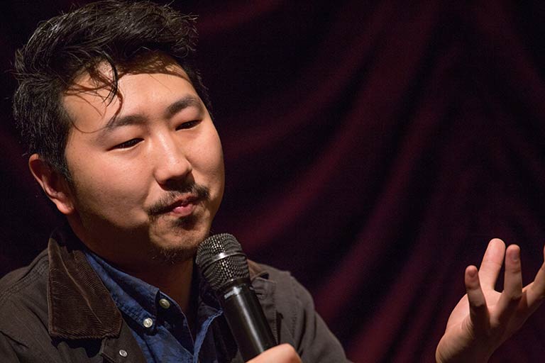 Andrew Ahn speaking with a microphone